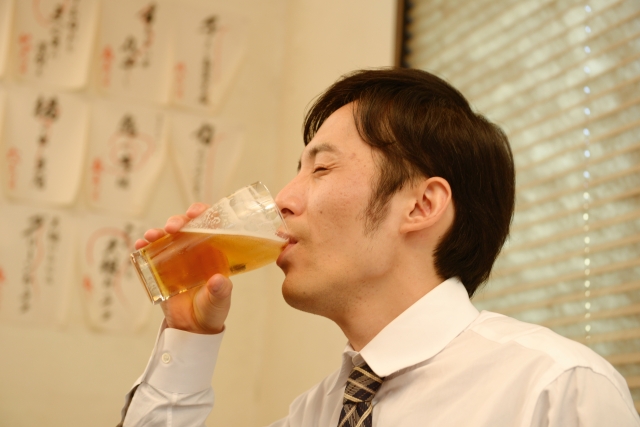 お酒を飲んでいる中年男性のイメージ画像